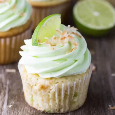 Delicious coconut cupcakes with lime buttercream frosting on a white plate.