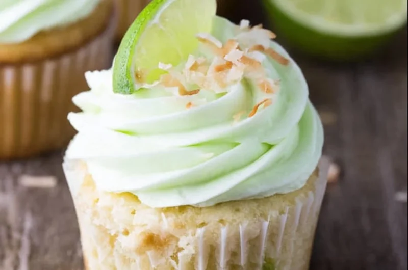 Delicious coconut cupcakes with lime buttercream frosting on a white plate.