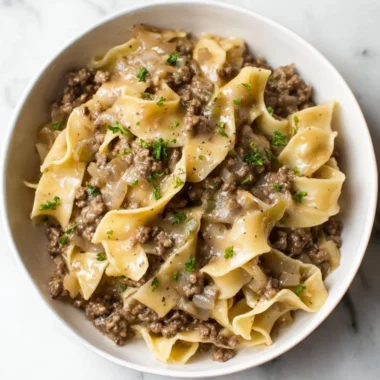A delicious bowl of beef and noodles served with fresh herbs.