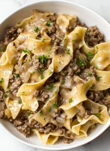 A delicious bowl of beef and noodles served with fresh herbs.