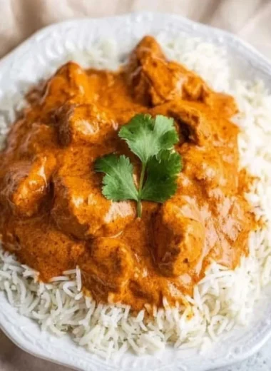 Delicious butter chicken served with rice and naan bread