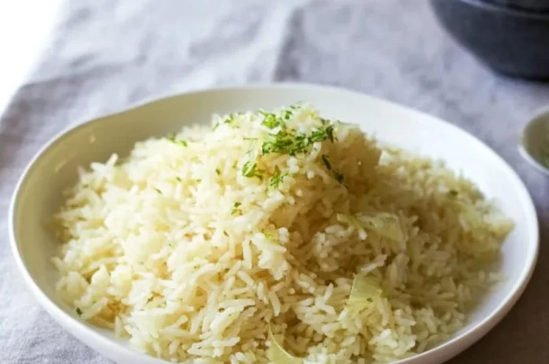 Creamy butter rice served in a bowl, garnished with herbs.