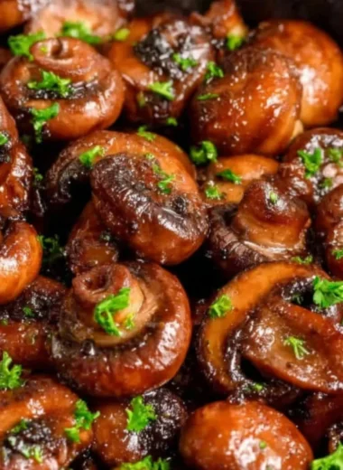 Plate of buttery sautéed mushrooms garnished with herbs
