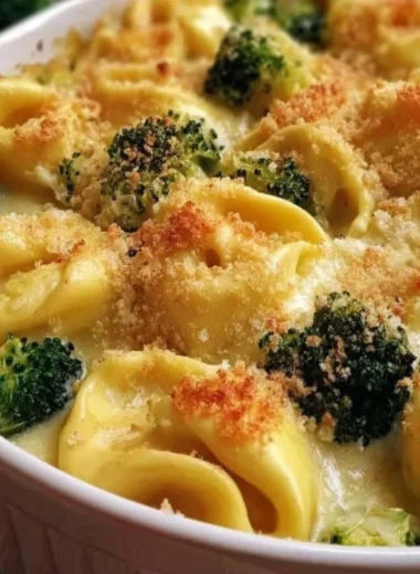 Cheesy Broccoli Tortellini Bake topped with melted cheese and broccoli florets