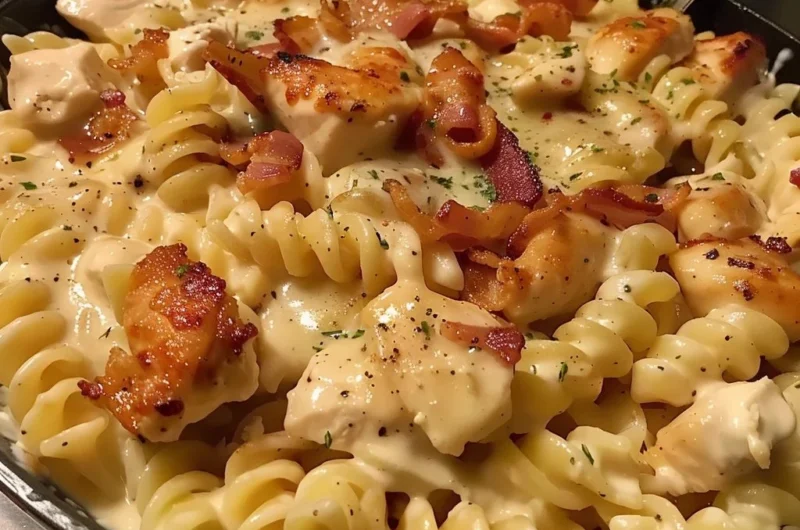 Bowl of creamy Chicken Bacon Ranch Pasta topped with herbs and cheese.