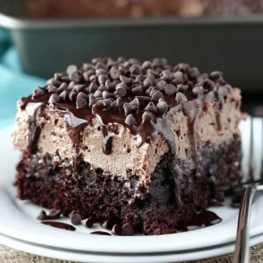 Delicious Chocolate Poke Cake with chocolate frosting and toppings