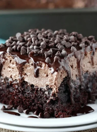 Delicious Chocolate Poke Cake with chocolate frosting and toppings