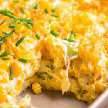 Deliciously creamy cream cheese corn casserole served hot in a baking dish.
