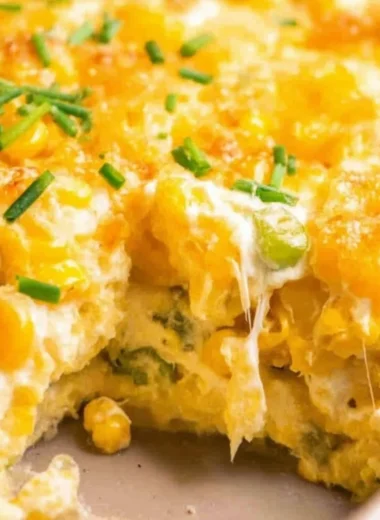Deliciously creamy cream cheese corn casserole served hot in a baking dish.