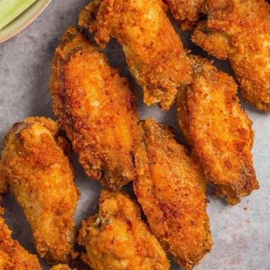 Crispy air fryer chicken wings served on a platter with fresh herbs