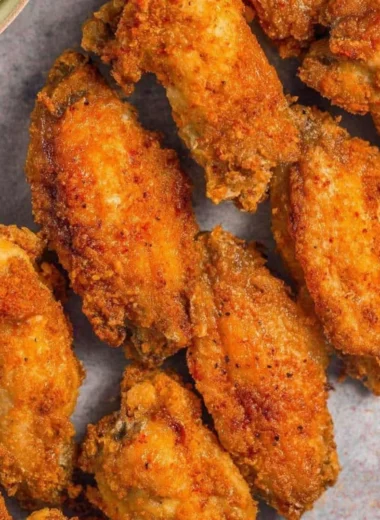 Crispy air fryer chicken wings served on a platter with fresh herbs