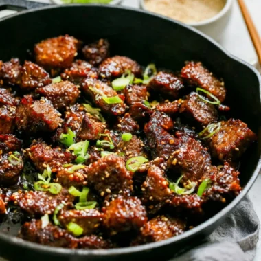 Easy Korean steak bites served on a plate with dipping sauce and garnishes.
