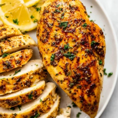 Juicy air fryer chicken breast served with fresh herbs and vegetables