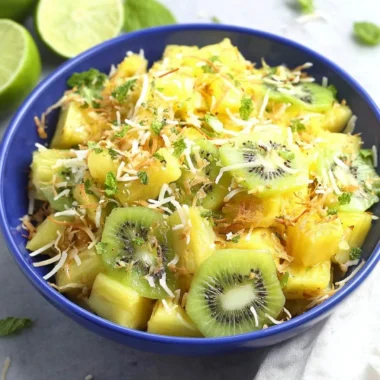 Fresh and colorful Pineapple Kiwi Salad in a bowl with mint leaves