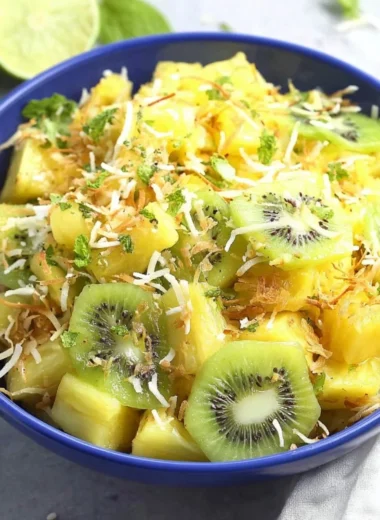 Fresh and colorful Pineapple Kiwi Salad in a bowl with mint leaves