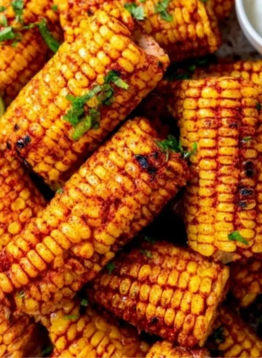 Plate of flavorful roasted corn ribs garnished with spices and herbs