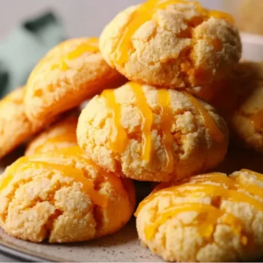Delicious tropical mango cookies on a wooden plate topped with coconut flakes.