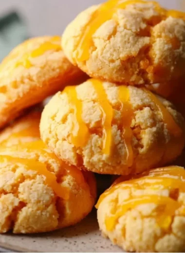Delicious tropical mango cookies on a wooden plate topped with coconut flakes.