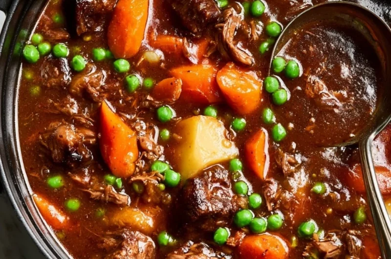 A bowl of homemade beef stew garnished with herbs and vegetables.