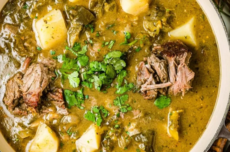 Homemade broth simmering with vegetables and herbs in a pot.