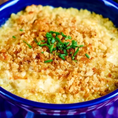 Cheesy quinoa mac and cheese topped with herbs in a bowl
