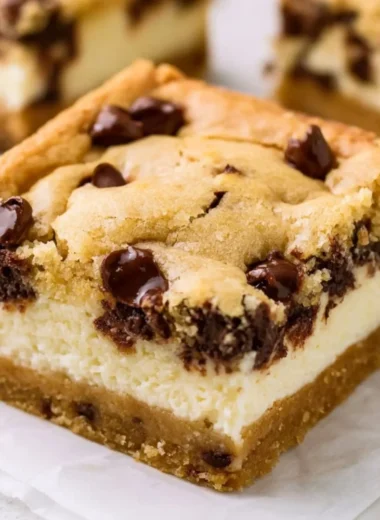 Delicious chocolate chip cheesecake bars on a white plate