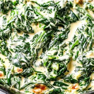 Delicious serving of creamed spinach in a bowl garnished with herbs