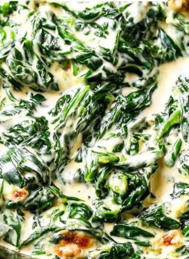 Delicious serving of creamed spinach in a bowl garnished with herbs