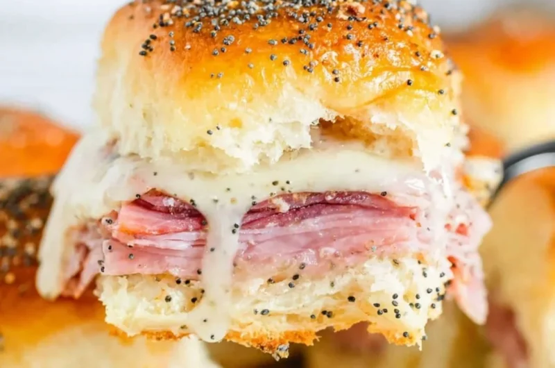 Baked ham and cheese sliders served on a platter.
