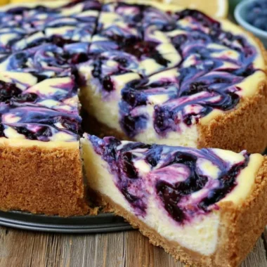 Slices of lemon blueberry cheesecake with fresh blueberries on top.