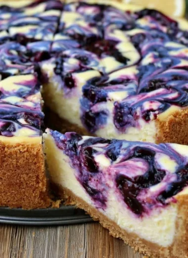 Slices of lemon blueberry cheesecake with fresh blueberries on top.