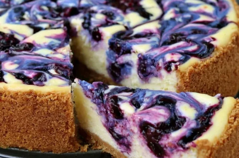 Slices of lemon blueberry cheesecake with fresh blueberries on top.