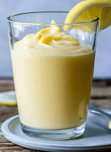 Delicious lemon cream dessert topped with zest and fresh lemon slices