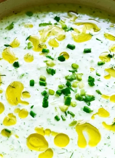 Chilled no-cook cucumber gazpacho served in a bowl with fresh herbs