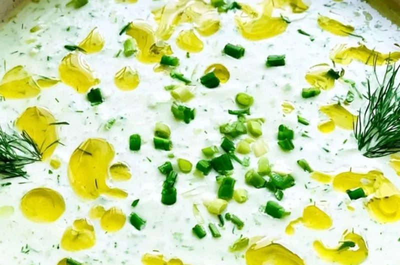 Chilled no-cook cucumber gazpacho served in a bowl with fresh herbs