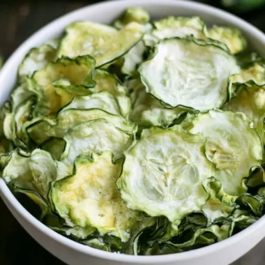 Salt and vinegar cucumber chips served in a bowl, a healthy snack alternative.