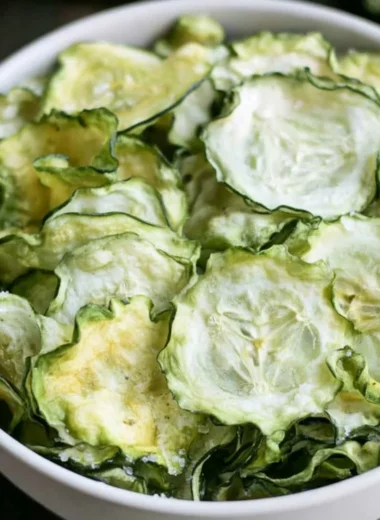 Salt and vinegar cucumber chips served in a bowl, a healthy snack alternative.