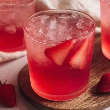 Glass of refreshing strawberry iced tea with fresh strawberries