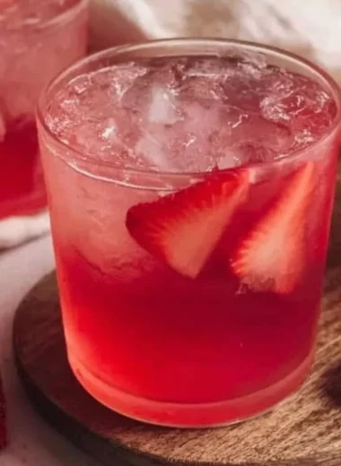 Glass of refreshing strawberry iced tea with fresh strawberries