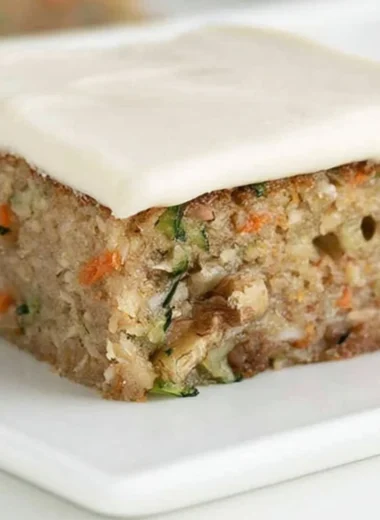 Delicious homemade zucchini bars topped with frosting on a plate