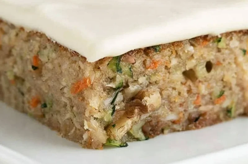 Delicious homemade zucchini bars topped with frosting on a plate