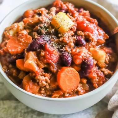 Bowl of hearty Turkey Apple Chili garnished with fresh herbs