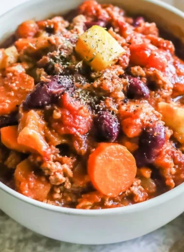 Bowl of hearty Turkey Apple Chili garnished with fresh herbs