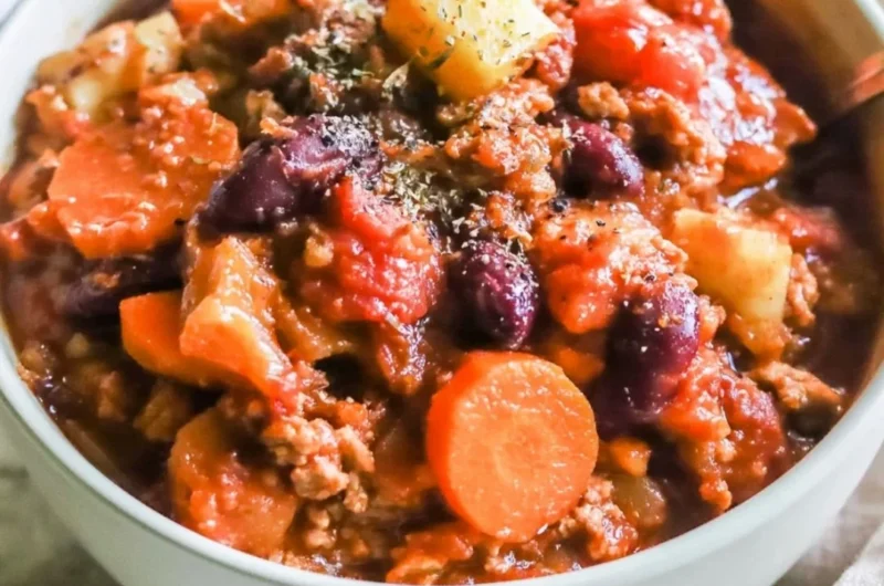 Bowl of hearty Turkey Apple Chili garnished with fresh herbs