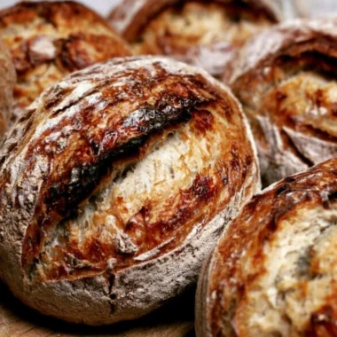 Freshly baked sourdough bread made from starter, showcasing a golden crust and airy interior.