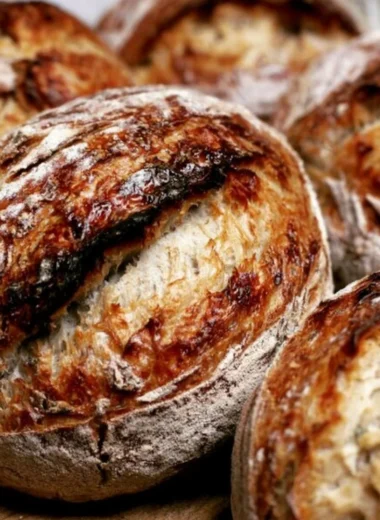 Freshly baked sourdough bread made from starter, showcasing a golden crust and airy interior.