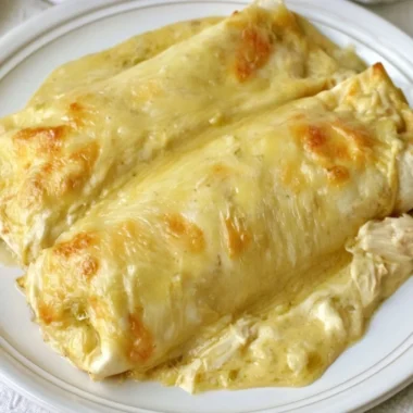 Creamy white chicken enchiladas topped with cheese and herbs