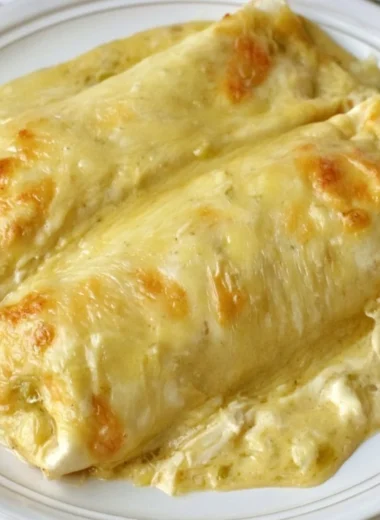 Creamy white chicken enchiladas topped with cheese and herbs
