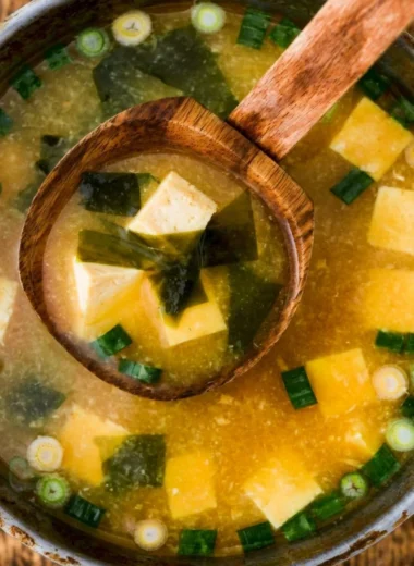 Bowl of homemade miso soup with tofu, green onions, and seaweed