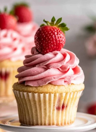 Delicious strawberry jam cupcakes topped with frosting and fresh strawberries